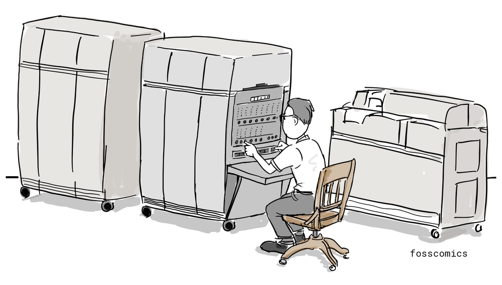 An operator sits at the control console of an IBM 650 computer, beside its separate cabinets and card equipment.